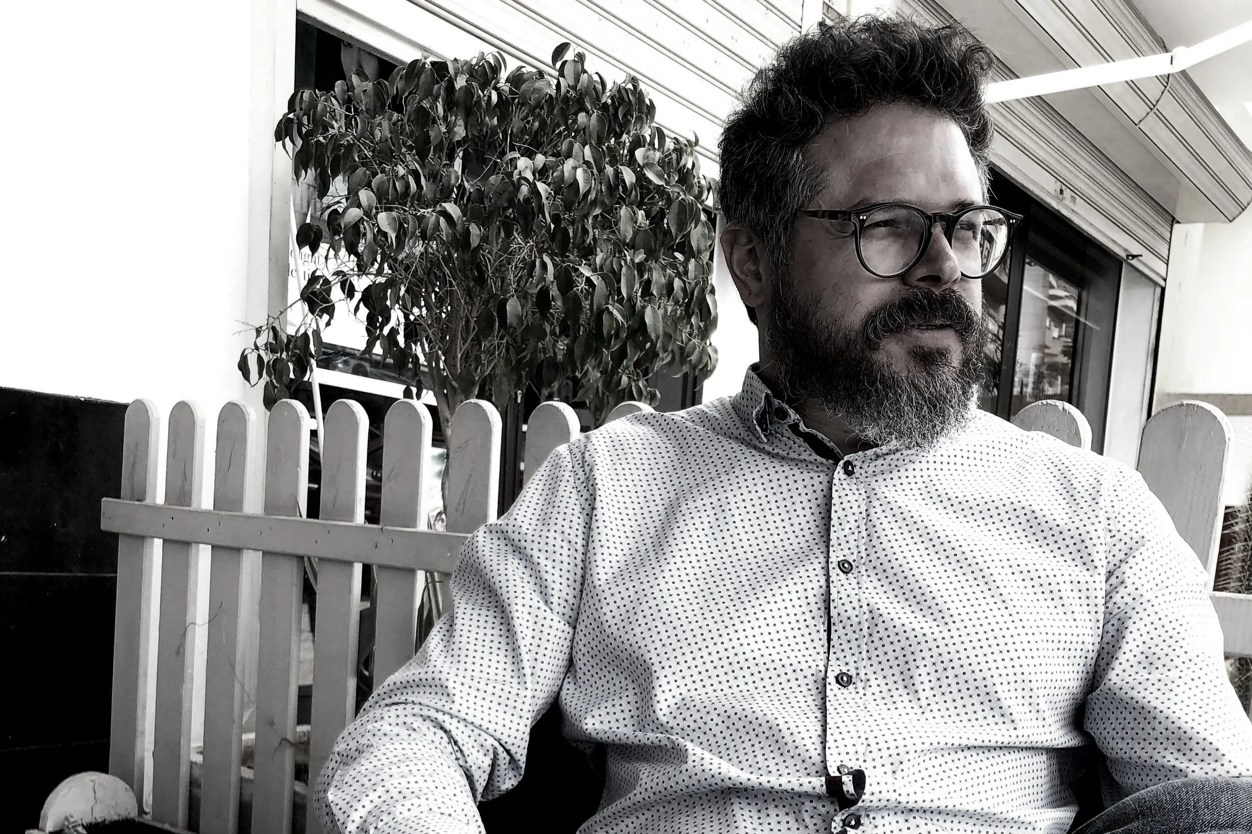 El Chef John Guerrero, retrato en blanco y negro con gafas y barba en una terraza